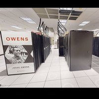 Interior of the Ohio Supercomputer Center showing server racks with a vertical banner with an image of Jesse Owens with a title text in red "OWENS" and smaller black text under the image "Jesse Owens."